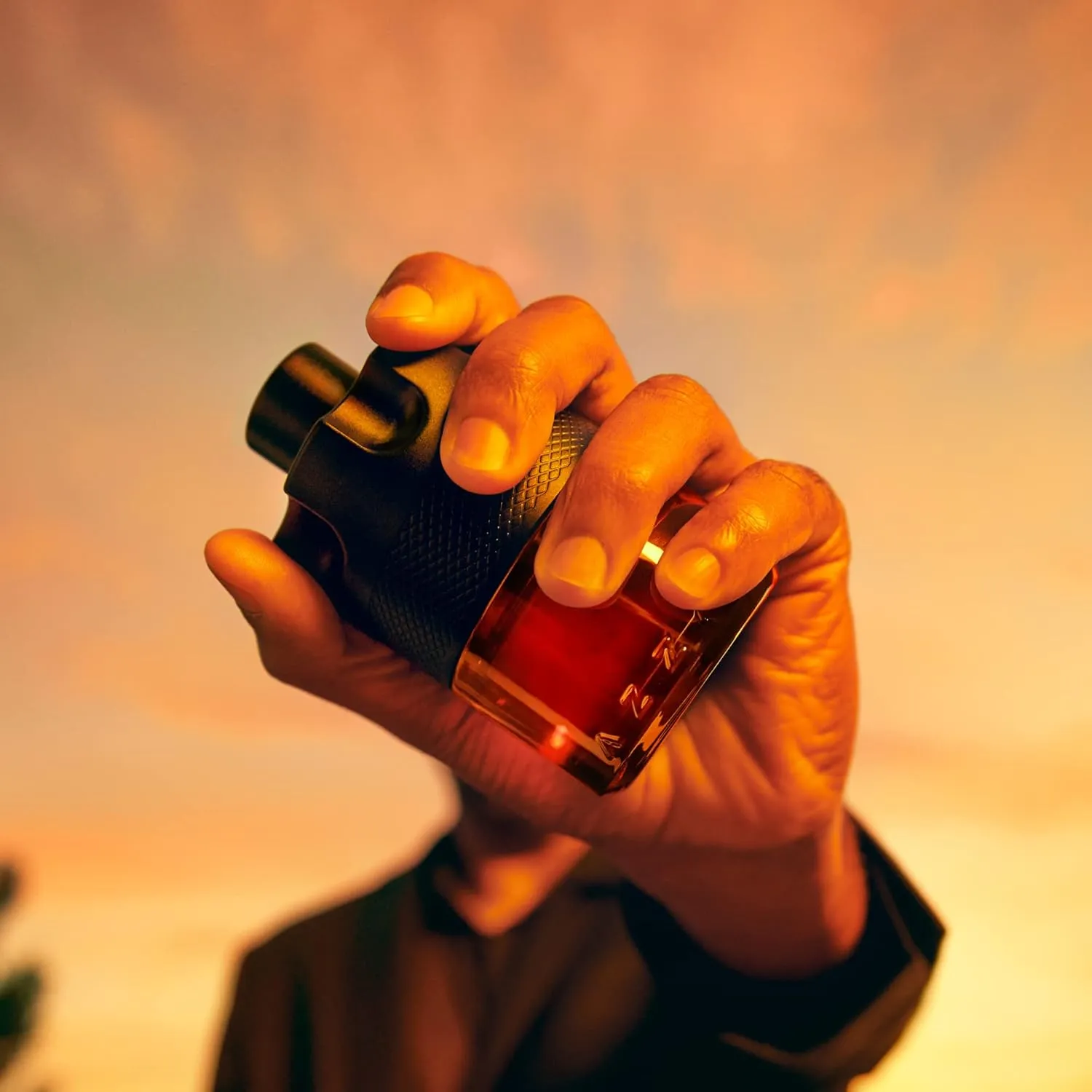 Azzaro The Most Wanted Parfum held in warm amber light