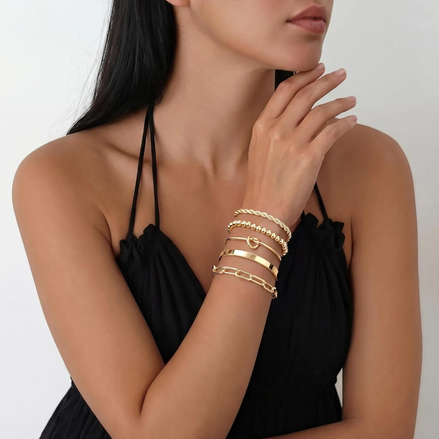 Gold bracelet stack worn with a black dress