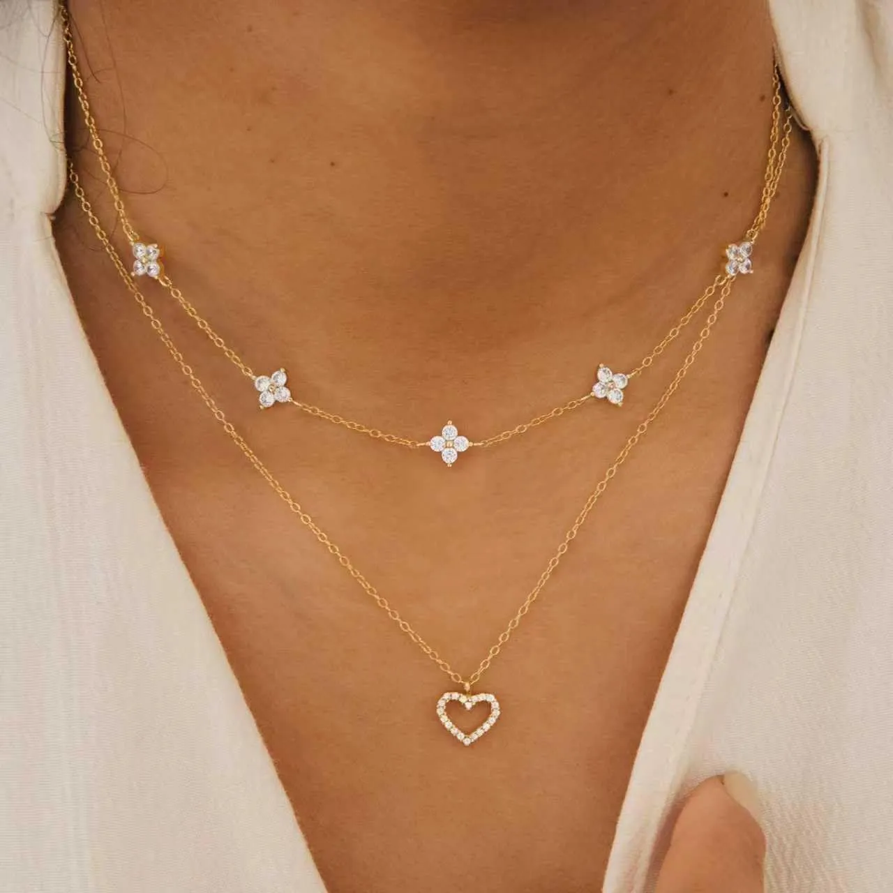 Dainty gold station necklace worn with a white top