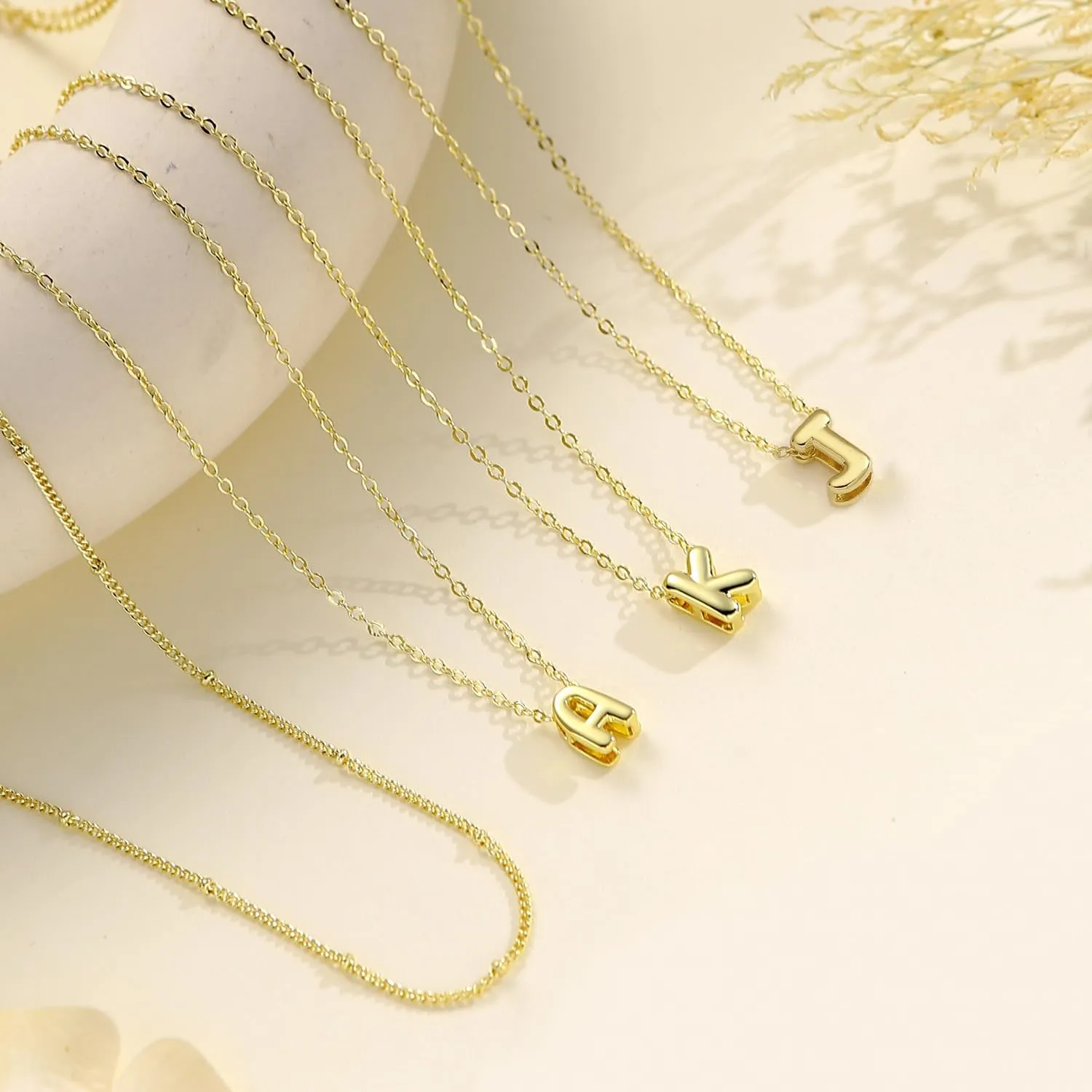 Gold initial necklace worn with a white top