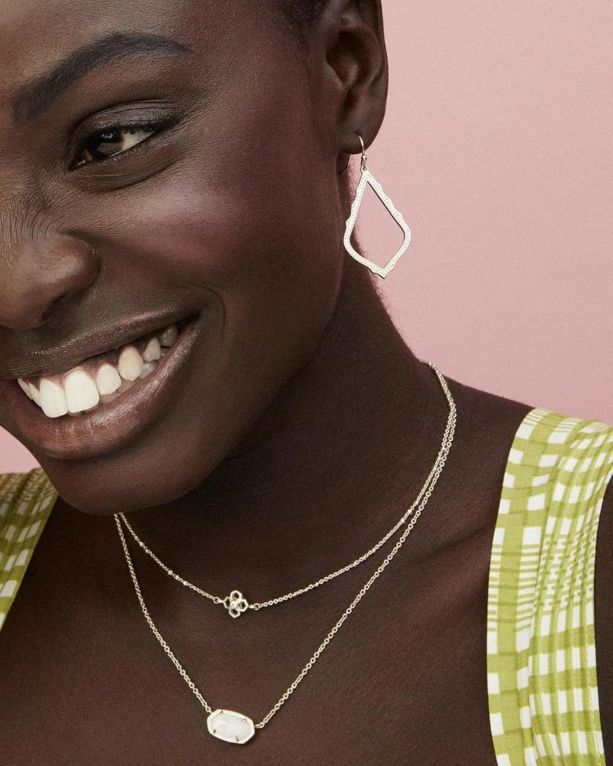 Model wearing a delicate Kendra Scott necklace and earrings