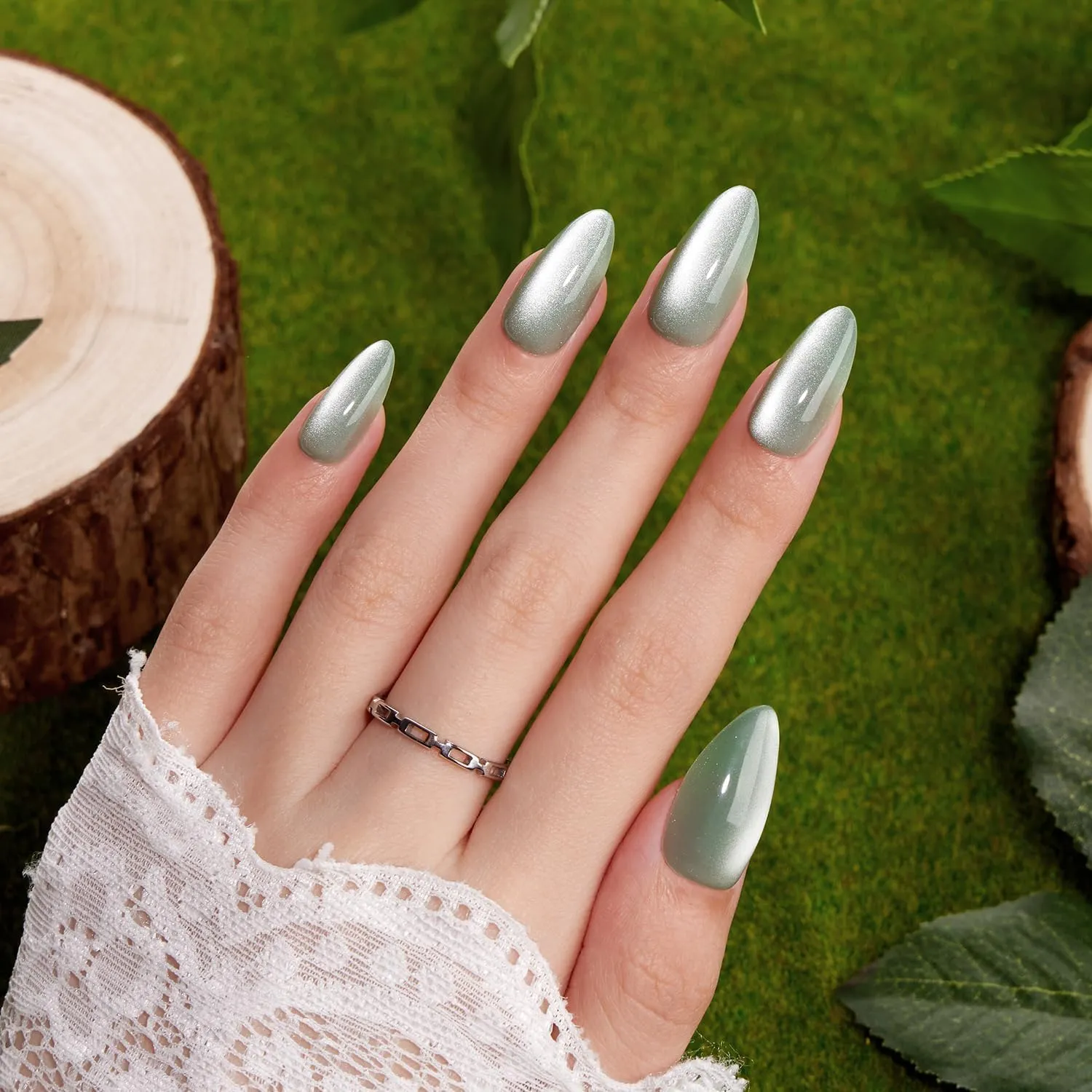 VSALON green shimmer almond nails shown on a hand with a silver ring